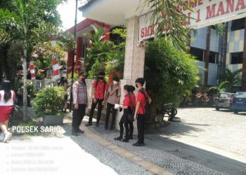 Kanit Samapta Polsek Sario Ipda S.Kalangi memantau anak-anak sekolah yang ada di Sekolah SMK N 1 Manado dan SMA N 1 Manado