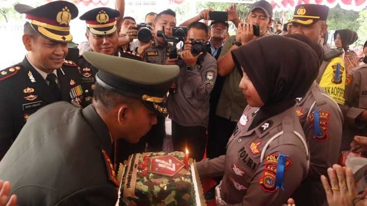Kapolres Lhokseumawe AKBP Henki Ismanto, SIK memberi surprise ke Dandim 0103/Aut, Letkol INF Hendrasari Nurhono, SIP, MIP di Lapangan Hiraq