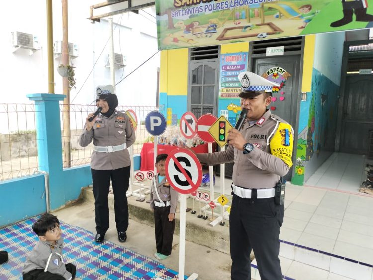 Personel Sat Lantas Polres Lhokseumawe mengenalkan rambu - rambu lalulintas ke anak TK Kemala Bhayangkari Lhokseumawe