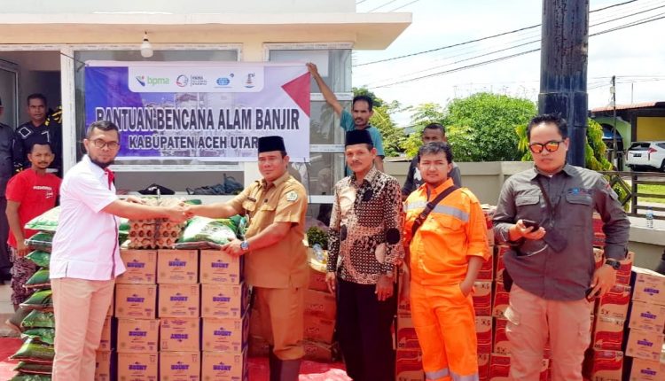 Field manager PGE, Ruzi Abd Muis bersama perwakilan Surveyor Indonesia menyerahkan bantuan masa panik di posko banjir Lhoksukon yang diterima oleh camat Kecamatan Lhoksukon, Hanifza Putra S.STP, M.Si.