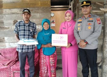 Ketua Bhayangkari Cabang Lhokseumawe, Ny Resti Henki Ismanto menyerahkan bantuan kepada warga kurang mampu di Kecamatan Meurah Mulia