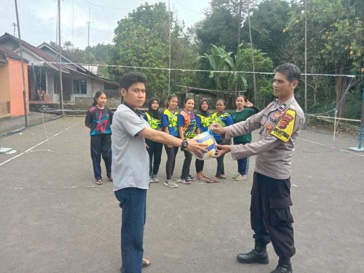 Bhabinkamtibmas Kelurahan Leuwiliang AIPTU Anas menyerahkan bola voli kepada warga di Kampung Babakan Rengrang Kelurahan Leuwiliang Kecamatan Kawalu