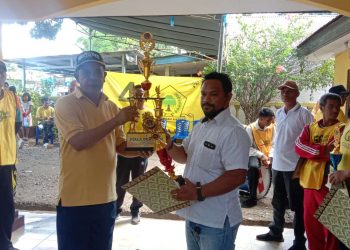 Aipda Denny Amtiran saat menerima piala tetap dari Ketua DPD Golkar Kabupaten Belu