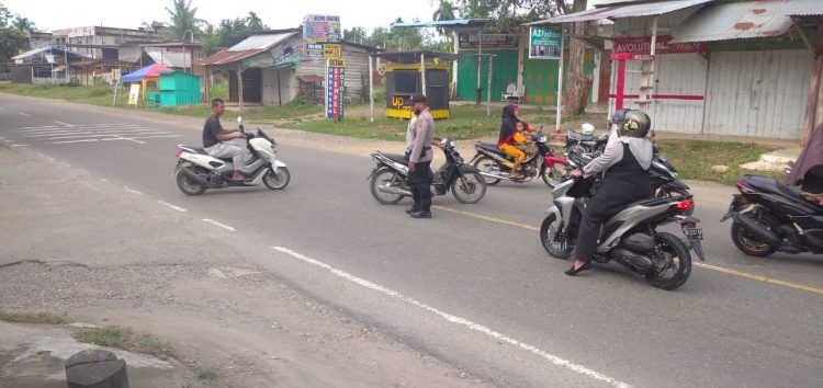 Personel Polsek Muara Batu melakukan pengaturan lalulintas di Jalan Medan - Banda Aceh tepatnya di Simpang Pendidikan
