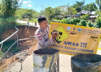 Anggota Kepolisian Sektor Tasifeto Timur (Polsek Tastim) Polres Belu - NTT melakukan pemasangan Garis Polisi (Police Line) dilokasi jalan Longsor didepan pasar Sabete Wedomu, Dusun Lamasi B, Desa Manleten
