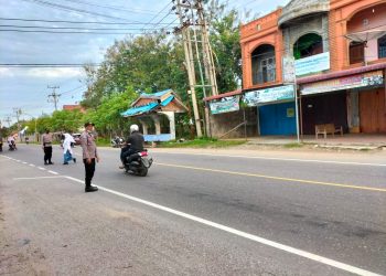Personel Polsek Syamtalira Bayu melaksanakan pengaturan lalulintas (strong poin) di Simpang Cot Plieng