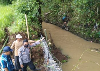 Bhabinkamtibmas Desa Sukaratu AIPDA Ali Susanto gotong royong menanggulangi banjir dengan memperbaiki Tanggul Cipagor yang jebol di Desa Sukaratu