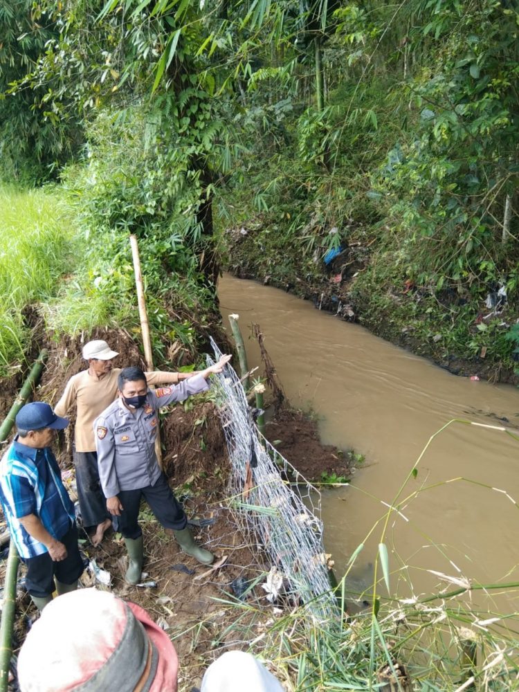 Bhabinkamtibmas Desa Sukaratu AIPDA Ali Susanto gotong royong menanggulangi banjir dengan memperbaiki Tanggul Cipagor yang jebol di Desa Sukaratu