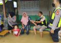 Tim Kedokteran dan Kesehatan Polres Tasikmalaya Kota melaksanakan kegiatan pengobatan gratis dan trauma healing untuk warga korban banjir di Kecamatan Sukaresik