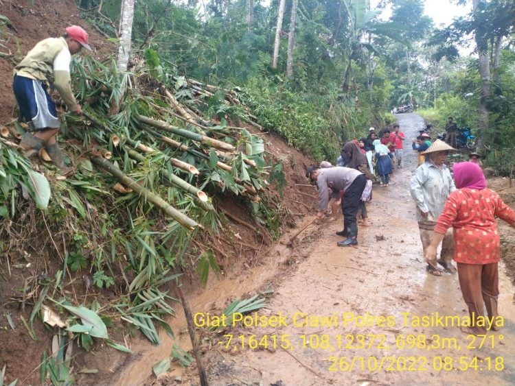 Bhabinkamtibmas Desa Citamba AIPDA Wawan gotong royong bersama warga bersihkan longsoran tanah yang menimbun akses jalan warga di Kampung Citamba