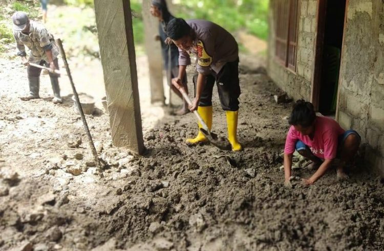 Bhabinkamtibmas Polsek Lamaknen Polres Belu, Brigpol. Richardus A. Botun yang bersama warga setempat turun melakukan pembersihan sisa lumpur yang telah mengering dan masih tersisa disekitaran rumah