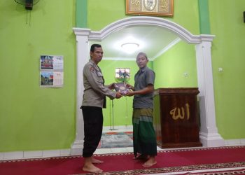 Aipda Muhammad Aliudin, SH personil Bid Humas Polda Sumsel membagikan Al-Qur’an ke Musholah