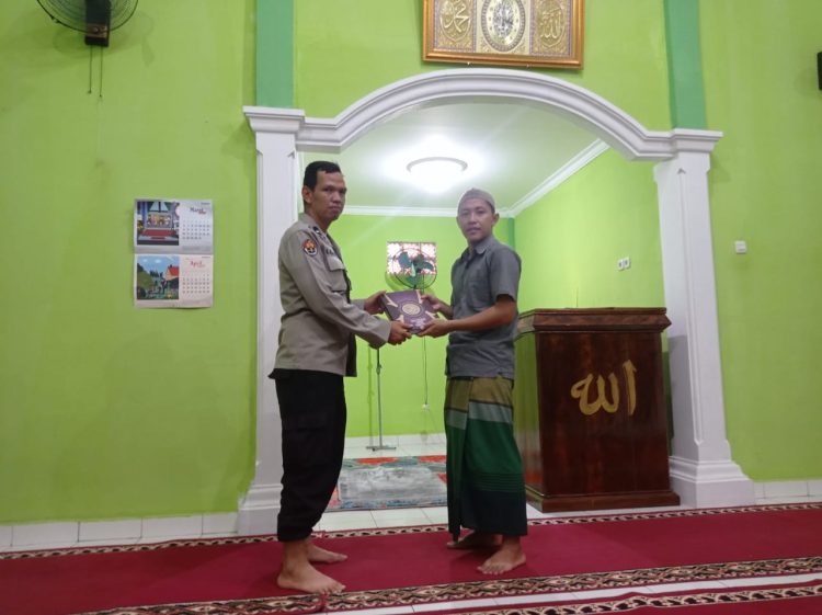 Aipda Muhammad Aliudin, SH personil Bid Humas Polda Sumsel membagikan Al-Qur’an ke Musholah