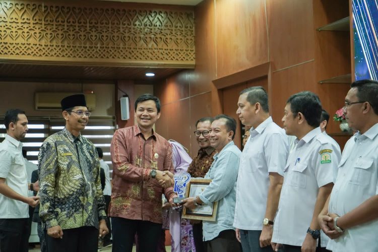 Penghargaan diserahkan oleh Staf Ahli Gubernur Aceh Bidang Keistimewaan Aceh, Sumber Daya Manusia dan Hubungan Kerjasama, Ir. Iskandar Syukri, M.M.,M.T kepada Pj. Bupati Nagan Raya, Fitriany Farhas, AP. S.Sos., M.Si yang diwakili Asisten Ekonomi dan Pembangunan Sekdakab Nagan Raya, Amran Yunus, S.P., M.T,