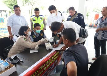 TES URINE: Personel Direktorat Reserse Narkoba Polda Sumut tes urine supir Angkutan Kota Antar Provinsi (AKAP) di Terminal Pinang Baris Medan, Senin (26/12/22). (Foto Dok/ Polda Sumut)