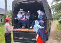 Personel SPN Polda Sumut, Aipda Zulkifli Sirait dengan sigap membantu mengantar anak-anak di Desa Cempa yang akan berangkat sekolah (foto : Polda Sumut)