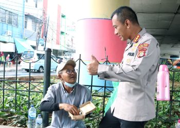 Polres Metro Jakarta Timur membagikan makanan nasi box dan minuman gratis kepada warga kurang yang ada di sekitar Terminal Kampung Melayu Jatinegara