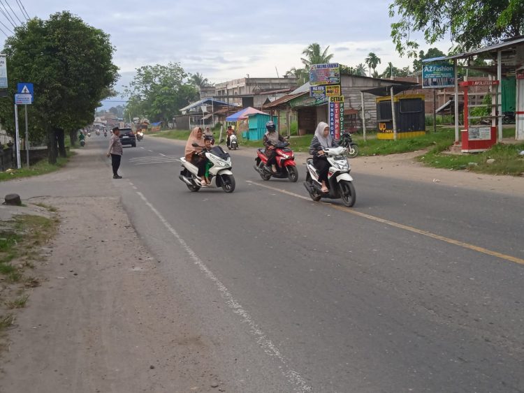 Personel Polsek Muara Batu melaksanakan strong poin atau pengaturan lalulintas di Jalan Medan - Banda Aceh