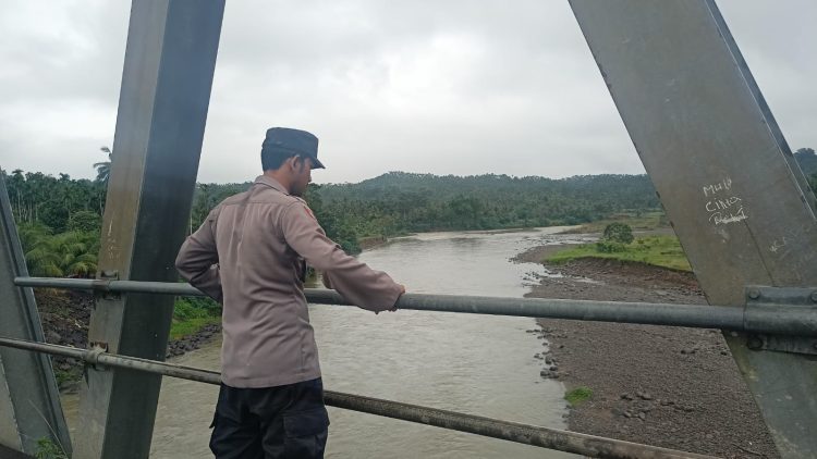 Personel Polsek Sawang memantau debit air sungai di Kecamatan Sawang, Aceh Utara