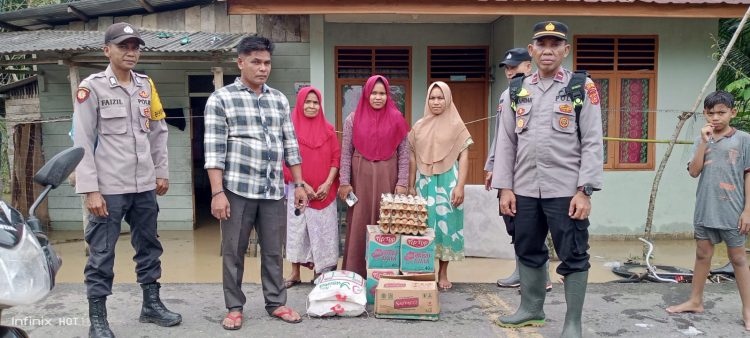 Personil Polsek Paya Bakong Ipda Iskandar, menyerahkan bantuan sosial tanggap darurat korban banjir Gampong Jok, Kecamatan Paya Bakong