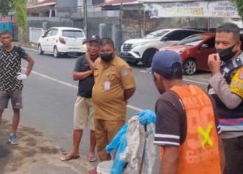Personil Polresta Manado bersama dengan masyarakat bergotong royong dalam memperbaiki jalan yang rusak