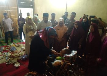 Penjabat (Pj) Bupati Nagan Raya, Fitriany Farhas, S.Sos, M.Si menepung tawari (peusijuk) Diki Fadillah (7), seorang anak penderita hydrosefalus
