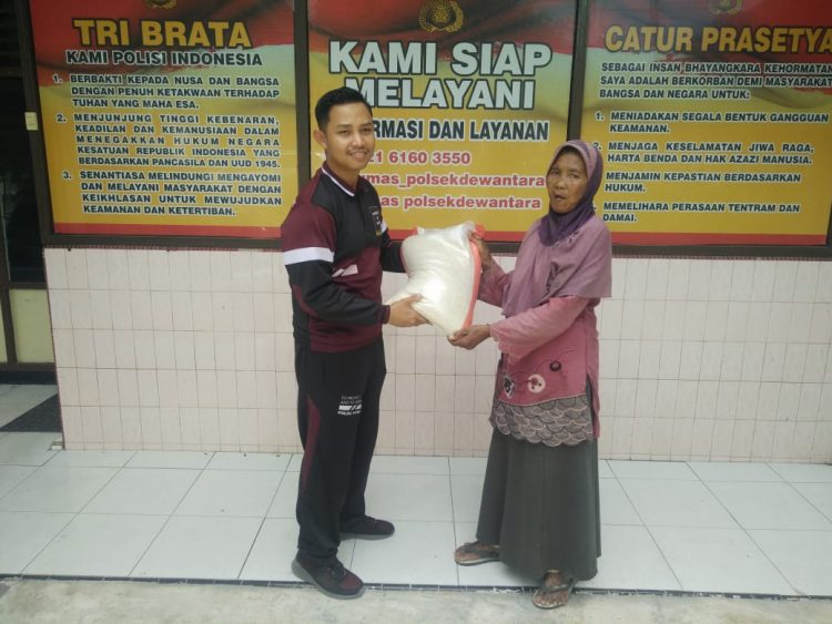 Personel Polsek Dewantara memberikan bantuan berupa sembako kepada warga kurang mampu
