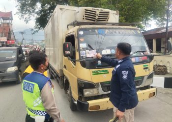 AKBP Dr. Herwansyah Putra, S.H., M.Si bersama personel Polres Toba bagi stiker F1 Power Boat Lake Toba kepada pengendara, Kamis (19/1/23). (Foto Dok/ Polda Sumut)