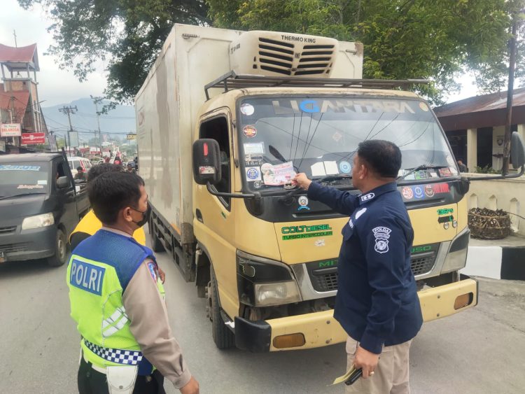 AKBP Dr. Herwansyah Putra, S.H., M.Si bersama personel Polres Toba bagi stiker F1 Power Boat Lake Toba kepada pengendara, Kamis (19/1/23). (Foto Dok/ Polda Sumut)