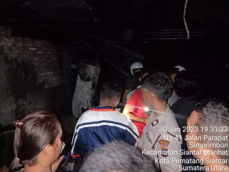 Kapolsek Siantar Marihat AKP Robert S Purba SH bersama dengan personel, membantu warga padamkan api pada saat terjadinya kebakaran milik warga bernama Andre Manik (30) di Jalan Parapat Km 6,5