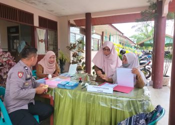 Bhabinkamtibmas Polsek Muara Batu memantau proses Penerimaan Peserta Didik Baru (PPDB) di SMA Negeri 1 Muara Batu