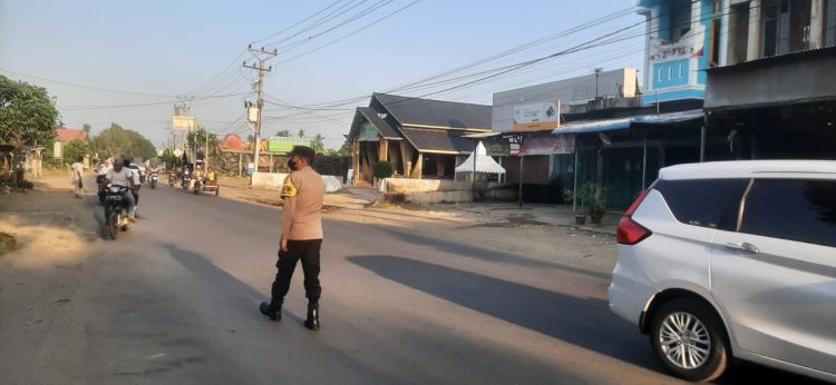 Personel Polsek Dewantara memberikan pelayanan kepada pengguna jalan raya di pagi hari di Simpang IV Keude Krueng Geukueh, Dewantara, Aceh Utara