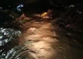 Air dengan intensitas yang cukup hingga membuat air meluap ke badan Jalan AMS Pekon Kota Agung pedukuhan way som