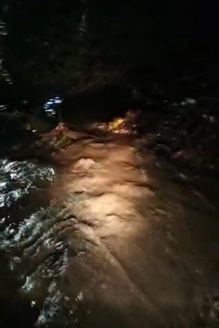 Air dengan intensitas yang cukup hingga membuat air meluap ke badan Jalan AMS Pekon Kota Agung pedukuhan way som