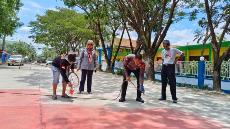 Personel Sat Lantas Polres Sidrap bekerjasama Dinas Perhubungan lakukan pengecetan Jalan di depan Paud Negeri Percontohan, Kamis (16/03/2023).