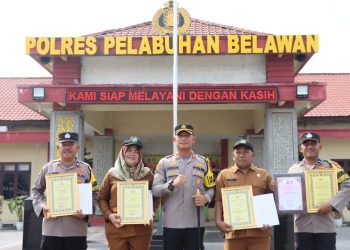 Kapolres Pelabuhan Belawan AKBP Josua Tampubolon, SH.,MH., memberikan reward kepada dua personil Bhabinkamtibmas dan juga dua orang kepling