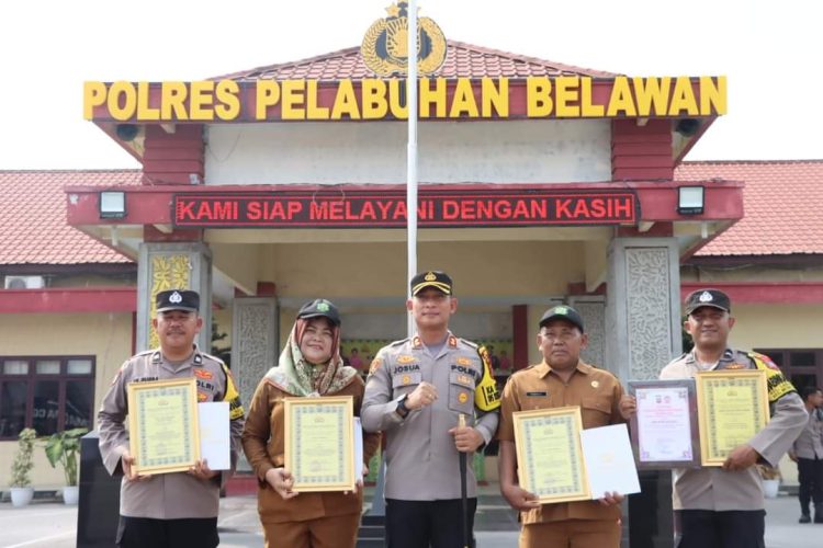 Kapolres Pelabuhan Belawan AKBP Josua Tampubolon, SH.,MH., memberikan reward kepada dua personil Bhabinkamtibmas dan juga dua orang kepling