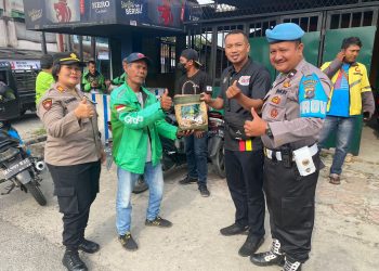 Kapolsek Siantar Utara AKP Herli D. Damanik SH bersama Kanit Intel Polsek Siantar Utara Ipda Saji dan Bhayangkari Polsek Siantar Utara sedang membagikan bingkisan kepada seorang pengendara
