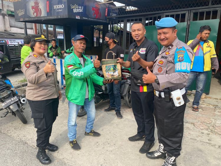 Kapolsek Siantar Utara AKP Herli D. Damanik SH bersama Kanit Intel Polsek Siantar Utara Ipda Saji dan Bhayangkari Polsek Siantar Utara sedang membagikan bingkisan kepada seorang pengendara