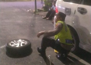 Personel Polsek Siantar Barat, hadir mengayomi tulus melayani masyarakat pemudik yang mengalami kempes ban mobil didepan toko roti ganda, Jalan Sutomo, Kelurahan Dwikora, Kecamatan Siantar barat, Kota Siantar, Minggu (23/04/2023)