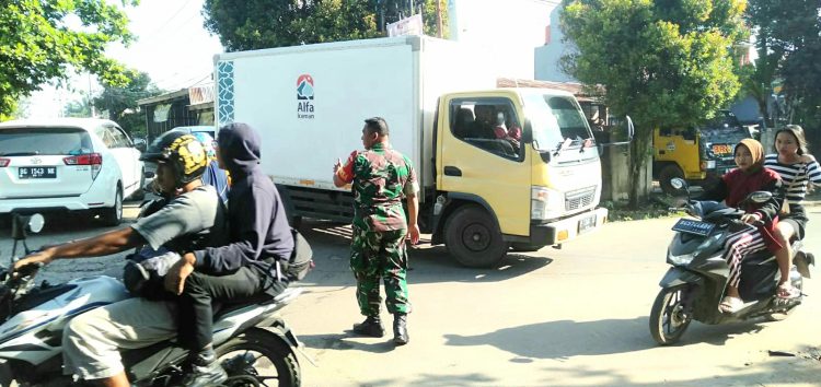 Babinsa Koramil 418-08/Sako, Kodim 0418/Palembang Serka Dudi Sukendar membantu mengatur arus Lalu Lintas di wilayah binaan di Jln. Simpang tiga pangeran Ayin Rt. 14 Rw. 01 Kel. Sako baru