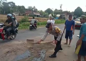 Polisi dari Polsek Kutasari melakukan pengaturan arus lalu lintas dan menutup tumpahan oli di ruas jalan raya Desa Meri, Kecamatan Kutasari, Kabupaten PurbaIingga,