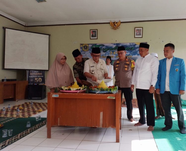 Pemotongan nasi tumpeng dalam rangka Tasyukuran ke-24 Kecamatan Sukamakmur  oleh Camat Sukamakmur Bapak Basri Hasan, didampingi tokoh agama, tokoh pemuda dan juga Kapolsek Sukamakmur Iptu Pranolo