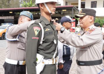 Kapolres Karo AKBP Wahyudi Rahman menyematkan pita kepada personel gabungan tanda dimulai Ops Patuh Toba 2023 di Mapolres Karo, Senin (10/7/2023).(Foto Dok/ Polres Karo)