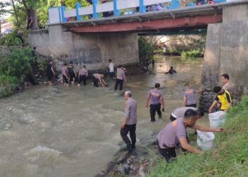Personel Polresta Deliserdang membersihkan sampah di pinggir Sungai Malinda Kecamatan Lubukpakam, Kamis (13/7/2023). (Foto Dok/ Polresta DS)