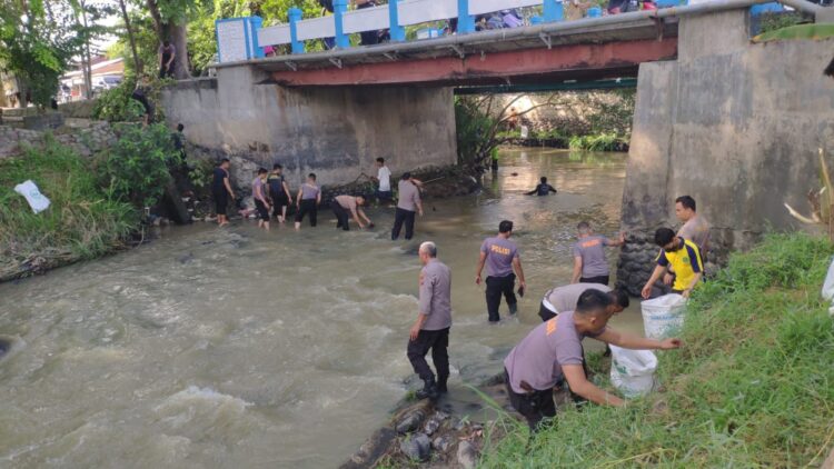 Personel Polresta Deliserdang membersihkan sampah di pinggir Sungai Malinda Kecamatan Lubukpakam, Kamis (13/7/2023). (Foto Dok/ Polresta DS)