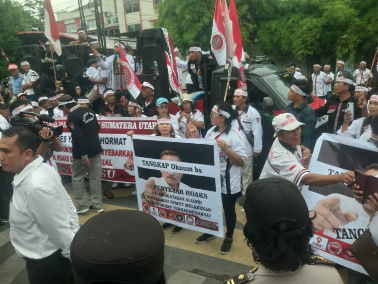AKSI DAMAI: Puluhan massa yang terdiri dari Aliansi Masyarakat Sumut dan HBB menggelar aksi damai di depan Mapolretastabes Medan Jalan HM Said Medan pada Senin (14/8/2023).(Foto /Tumpal Manik)