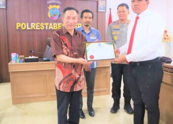 BERI PIAGAM PENGHARGAAN: Korban penipuan, Prof Xu Sizhong warga asal negara Malaysia memberikan piagam penghargaan kepada Kanit Pidsus Sat Reskrim Polrestabes Medan Iptu Widiyatma Lumbanraja dan disaksikan Konjen Malaysia Aiyub dan Waka Polrestabes Medan AKBP Yudhi Setiawan di Mapolrestabes, Jumat (18/8/2023).(Foto Dok/Polrestabes)