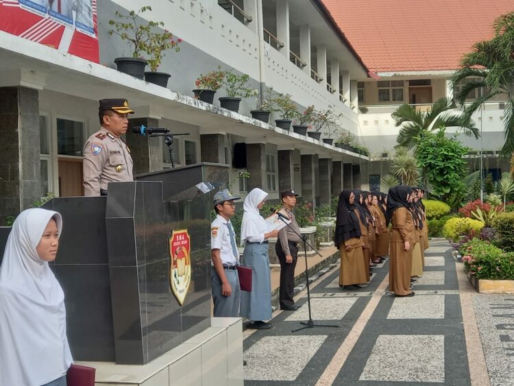JADI IRUP: Kasat Binmas Polrestabes Medan Kompol Kamdani menjadi Irup di SMA Negeri 1 Medan, Senin (21/8/2023).(Foto Dok/Polrestabes)