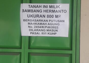 PEMBERITAHUAN : Pemilik menempelkan pemberitahuan di pintu ruko yang dimenangkan di tingkat MA, Sabtu (26/8). (Foto Dok/Warga)